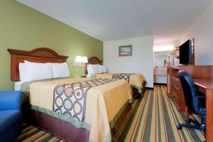 a hotel room with two beds and a desk at Cornerstone Inn & Suites Troy in Troy