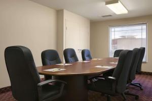Super 8 by Wyndham Fort Nelson BC في فورت نيلسون: قاعة اجتماعات مع طاولة وكراسي خشبية