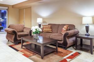 a living room with a couch and two tables at Super 8 by Wyndham Abbotsford BC in Abbotsford