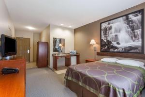 a hotel room with a bed and a flat screen tv at Super 8 by Wyndham Abbotsford BC in Abbotsford