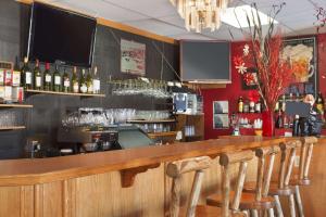 a bar with a counter with bottles of wine at Travel Inn Cochrane in Cochrane