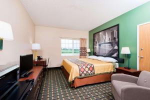 a hotel room with a bed and a flat screen tv at Super 8 by Wyndham Mt. Carmel IL in Mount Carmel