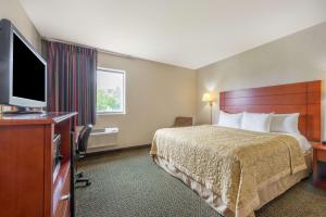 a hotel room with a bed and a flat screen tv at Super 8 by Wyndham St Charles in St. Charles