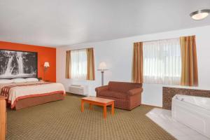 um quarto de hotel com uma cama e uma cadeira em Super 8 by Wyndham Cloverdale Wine Country em Cloverdale