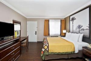 a hotel room with a bed and a flat screen tv at Super 8 by Wyndham Los Angeles-Culver City Area in Los Angeles