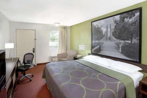 Habitación de hotel con cama grande y escritorio. en Super 8 by Wyndham Lafayette en Lafayette