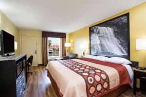 a hotel room with a large bed and a tv at Super 8 by Wyndham Garner/Clayton/Raleigh in Garner