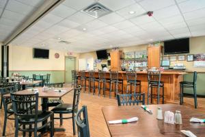 a restaurant with tables and chairs and a bar at Super 8 by Wyndham Grayville in Grayville