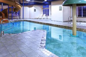 - une piscine d'eau bleue dans un hôtel dans l'établissement Super 8 by Wyndham Caraquet, à Caraquet