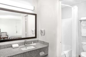 a bathroom with a sink and a mirror at Super 8 by Wyndham Lafayette in Lafayette