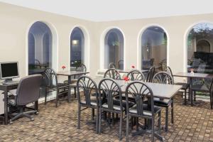 a group of tables and chairs in a restaurant at Super 8 by Wyndham Morton Grove/Chicago in Morton Grove