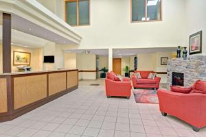 a lobby with red chairs and a fireplace at Super 8 by Wyndham Barrie South in Barrie