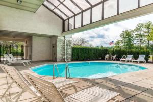 a swimming pool with chairs and a patio with at WestSpring Inn - Westlake Cleveland in Westlake
