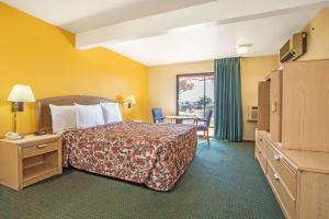 Habitación de hotel con cama y mesa en Travelodge by Wyndham Turlock, en Turlock