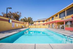 a swimming pool in front of a building at Travelodge by Wyndham Turlock in Turlock