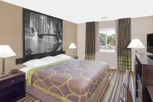 Habitación de hotel con cama y TV en Super 8 by Wyndham Morton Grove/Chicago, en Morton Grove