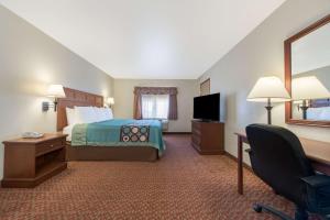 a hotel room with a bed and a television at Super 8 by Wyndham Abilene South in Abilene