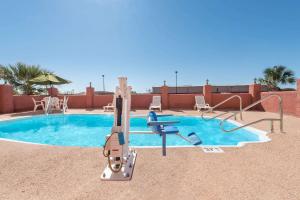 una piscina con tobogán y un parque infantil en Super 8 by Wyndham Abilene South, en Abilene