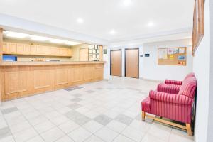 una gran sala de espera con 2 sillas rojas en Super 8 by Wyndham Sisseton, en Sisseton