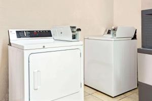 two machines and a washer and dryer in a room at Super 8 by Wyndham Fort Mitchell Cincinnati Area in Fort Mitchell