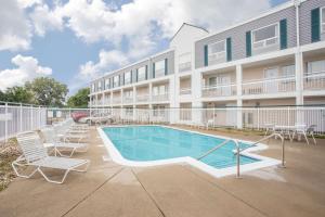 a swimming pool in front of a building at Super 8 by Wyndham Madison East in Madison