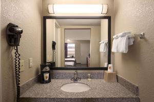 a bathroom with a sink with a phone and a mirror at Super 8 by Wyndham Chattanooga/East Ridge in Chattanooga
