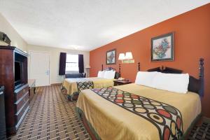 a hotel room with two beds and a flat screen tv at Super 8 by Wyndham Dallas South in Dallas