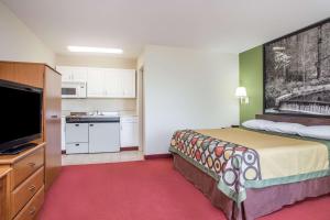 a hotel room with a bed and a kitchen at Super 8 by Wyndham Lavonia in Lavonia