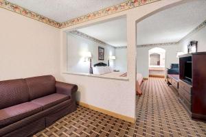 a living room with a couch and a bedroom at Super 8 by Wyndham Dallas South in Dallas