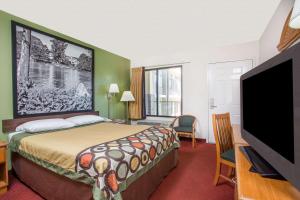 Habitación de hotel con cama y TV de pantalla plana. en Super 8 by Wyndham Lavonia, en Lavonia