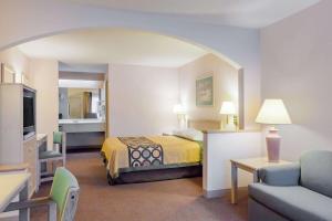 een hotelkamer met een bed en een woonkamer bij Super 8 by Wyndham Jasper TX in Jasper