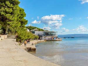 une plage avec un bâtiment à côté de l'eau dans l'établissement Apartments F&A, à Split