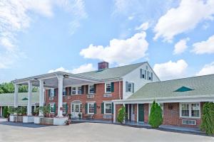 シーコンクにあるColonial Inn Seekonkの白屋根の大きな赤レンガ造り