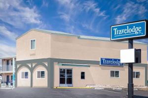 a building with a sign in front of it at Travelodge by Wyndham Barstow in Barstow