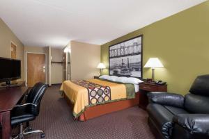a hotel room with a bed and a desk and a couch at Super 8 by Wyndham Miamisburg Dayton S Area OH in Miamisburg