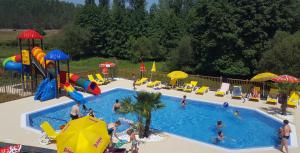 a group of people in a pool at a resort at Le Verdoyant in Thenon