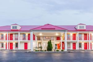 a large red and white building with a parking lot at Super 8 by Wyndham Clinton in Clinton