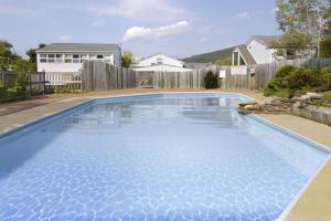 una piscina con acqua blu in un cortile di Howard Johnson by Wyndham Williamstown a Williamstown