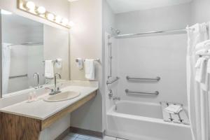 a bathroom with a sink and a tub and a shower at Super 8 by Wyndham Clinton in Clinton