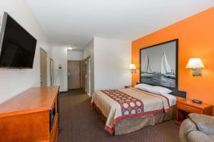 a hotel room with a bed and a flat screen tv at Super 8 by Wyndham Salina in Salina