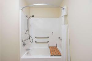a bathroom with a shower and a white tub at Super 8 by Wyndham Rolla in Rolla