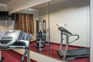a gym with a mirror and a treadmill at Super 8 by Wyndham Brookshire TX in Brookshire