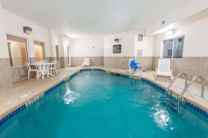 a swimming pool with blue water in a building at Super 8 by Wyndham Rolla in Rolla