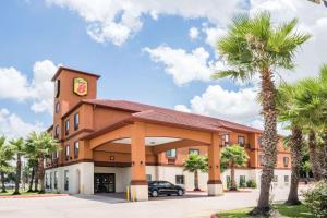 ein Hotel mit Palmen davor in der Unterkunft Super 8 by Wyndham Brookshire TX in Brookshire