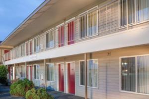 an apartment building with red doors and windows at Knights Inn Pasco in Pasco