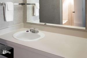 een badkamer met een witte wastafel en een spiegel bij Knights Inn Pasco in Pasco