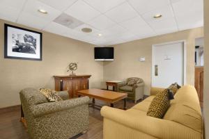 a waiting room with two couches and a tv at Super 8 by Wyndham Oxford in Oxford