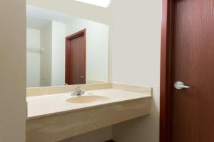 a bathroom with a sink and a mirror at Super 8 by Wyndham Beaver Falls in Beaver Falls