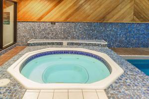 a jacuzzi tub in a bathroom with blue tiles at Super 8 by Wyndham Campbellton NB in Campbellton
