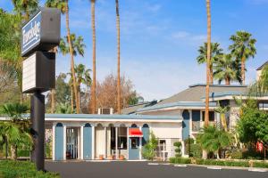 un edificio con palme di fronte ad esso di Travelodge by Wyndham Bakersfield a Bakersfield